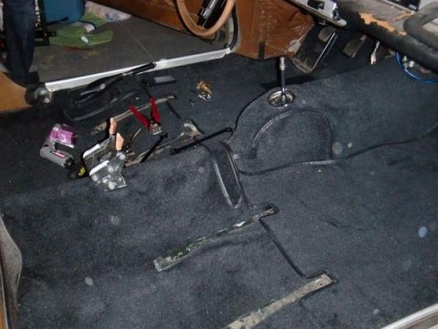 1969 Volvo P1800 - Car interior with carpet removed, showing floor components and tools.