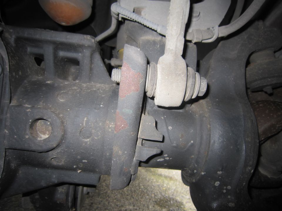 Close-up of a vehicle's suspension linkage and mounting bracket