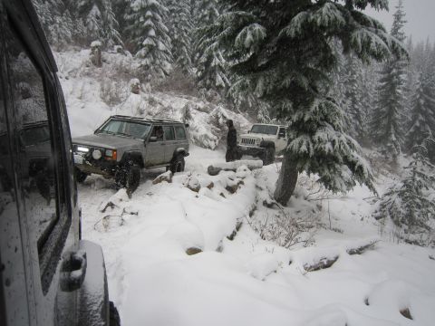 2008 Jeep Wrangler - Two Jeeps navigate a snow-covered forest trail, demonstrating off-road capability in winter conditions.