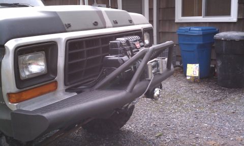 1979 Ford Bronco - The front of a 1979 Ford Bronco is shown with a custom bumper and winch, and a camouflage pattern on the hood.