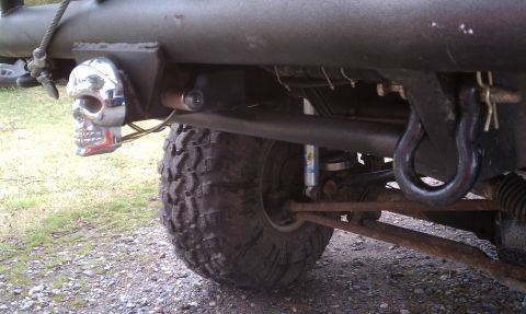 1979 Ford Bronco - Close-up of a vehicle's rear suspension and chassis, a skull-shaped taillight and tow hook.
