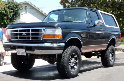 1995 Ford Bronco - This 1995 Ford Bronco features a dark blue exterior with a white removable top and a lifted suspension.