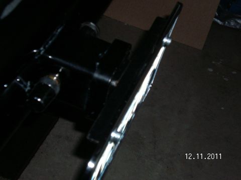 1996 Ford Bronco - Close-up view of a black receiver hitch plate bracket, showing mounting hardware and a reflective trim detail.