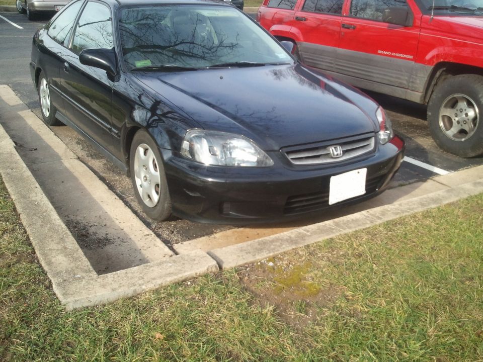 Black Honda Civic coupe parked front-3/4 view beside red Jeep Grand Cherokee