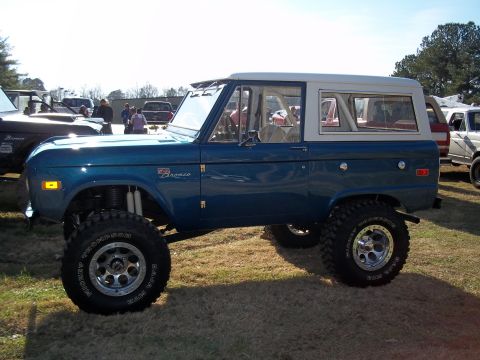 1979 Ford Bronco - Modified Ford Bronco sits on display with other vehicles at an outdoor event.