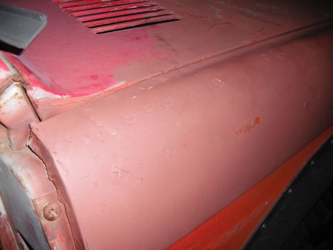 1968 Ford Bronco - Close-up of the hood and fender of a 1968 Ford Bronco, showing areas of rust and body imperfections.