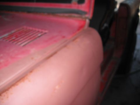 1968 Ford Bronco - Detail shot of a red vehicle's bodywork, highlighting areas of rust and a vent on the hood.