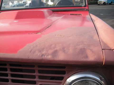 1968 Ford Bronco - Rust and body damage visible on the hood of a 1968 Ford Bronco.