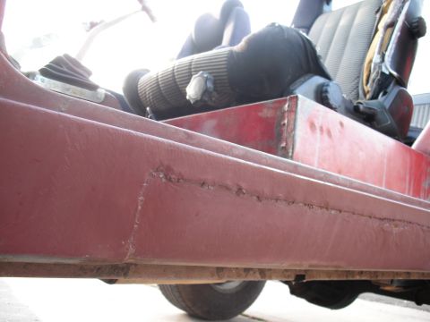 1968 Ford Bronco - Close-up of a vehicle's interior and red body panel, highlighting rust and body work.