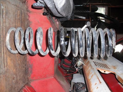 1968 Ford Bronco - A close-up view of a suspension coil spring inside a vehicle's cabin.