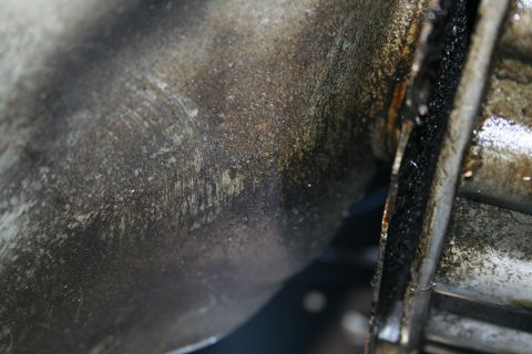 1982 Ford Bronco - This image shows a close-up of a greasy mechanical part, likely from a vehicle's drivetrain, with visible wear marks.