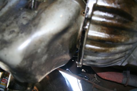 1982 Ford Bronco - Close-up view of the underside of a vehicle's transmission and oil pan, showing mechanical components.