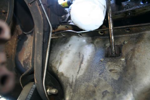 1982 Ford Bronco - Close-up view of an engine's oil pan and oil filter, with a drive belt in the foreground.