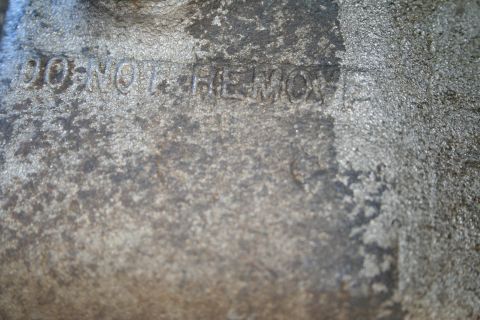 1982 Ford Bronco - Close-up of a cast metal component with "DO NOT REMOVE" stamped on its surface.