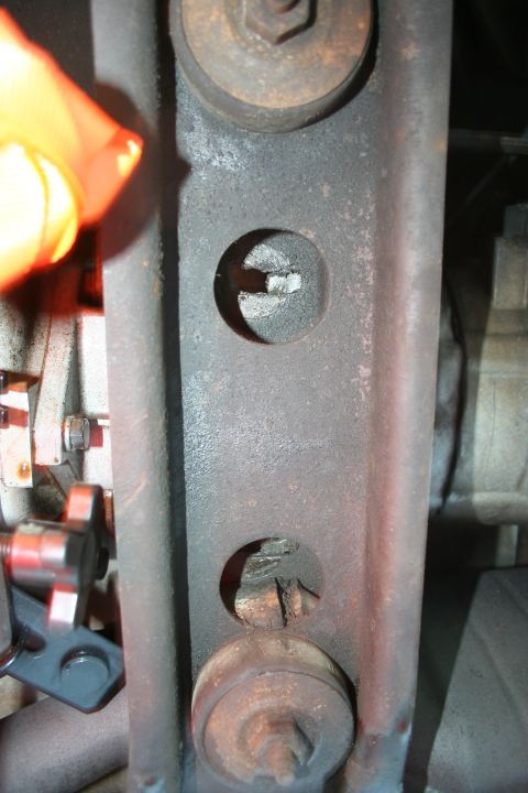 1982 Ford Bronco - A close-up view of a metal bracket, likely part of a vehicle's undercarriage, with visible bolts and holes.