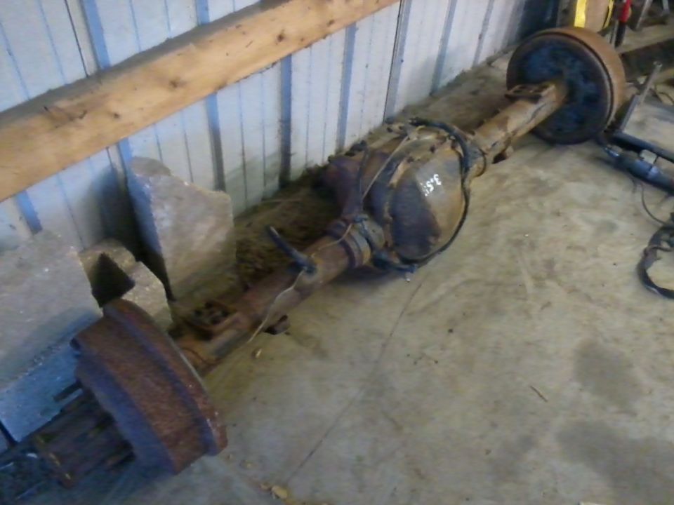 Rusty rear axle assembly with drum brakes, marked '3.55'