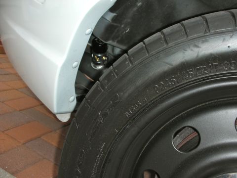 2004 Ford Crown Victoria - Close-up view of the front wheel well and suspension system on a 2004 Ford Crown Victoria.