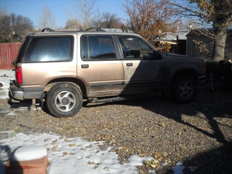 1992 Ford Explorer - This two-tone Ford Explorer SUV is parked outdoors on a gravel lot with scattered snow.