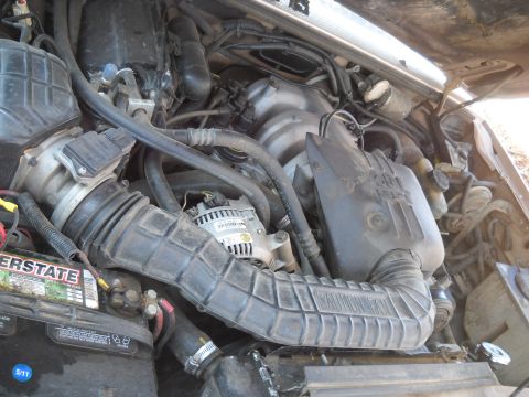 1992 Ford Explorer - The engine bay of a 1992 Ford Explorer is shown, revealing the battery and air intake system.
