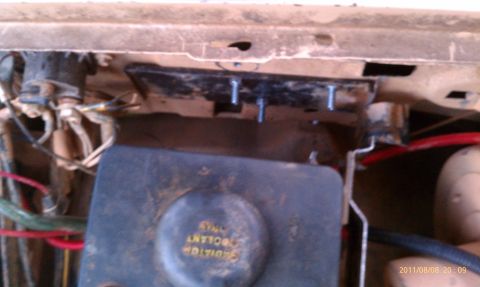 1987 Ford Bronco - The image shows a radiator overflow tank and associated wiring, likely from a vehicle's engine bay.