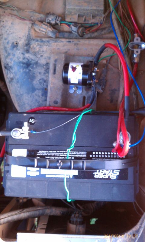 1987 Ford Bronco - Close-up view of the engine bay, showing a Super Start battery and various electrical connections.