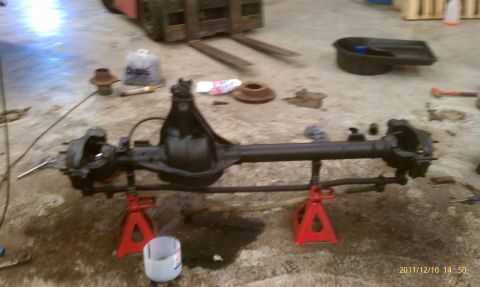 1987 Ford Bronco - Front axle assembly disassembled and supported on jack stands in a workshop setting.