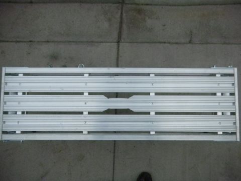1997 Ford Ranger - A silver aluminum slatted truck bed rack or platform, viewed from above on a concrete floor. The frame has multiple horizontal extruded alu…