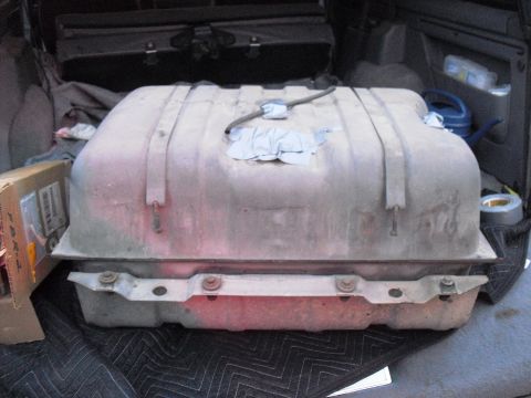 1986 Ford Bronco - A fuel tank is shown in the cargo area of a vehicle, placed on a protective mat.