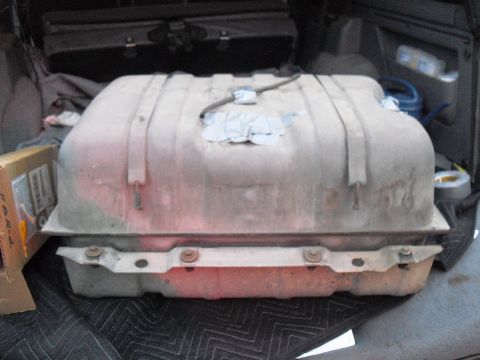 1986 Ford Bronco - A gas tank is shown inside the cargo area of a vehicle, resting on a protective mat.