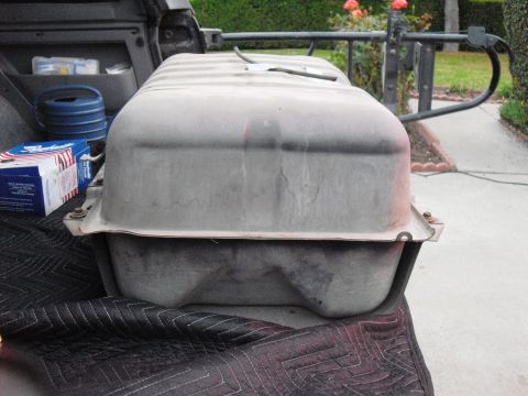 1986 Ford Bronco - A fuel tank is shown in the bed of a truck, with a blue container and a box of filters visible nearby.