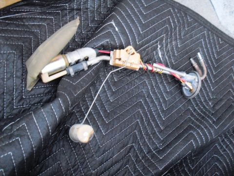 1986 Ford Bronco - Fuel pump and sending unit assembly removed from a vehicle, laid out on a protective mat.