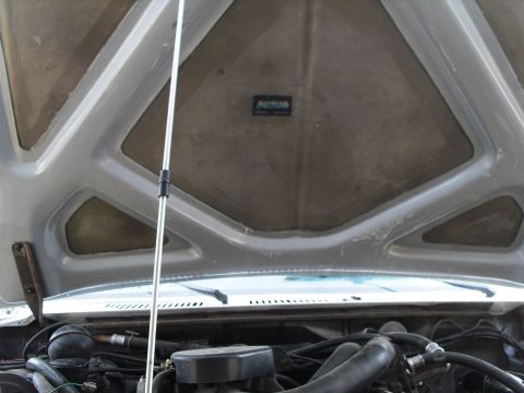 1986 Ford Bronco - The engine bay and hood insulation of a 1986 Ford Bronco are visible in this photo.
