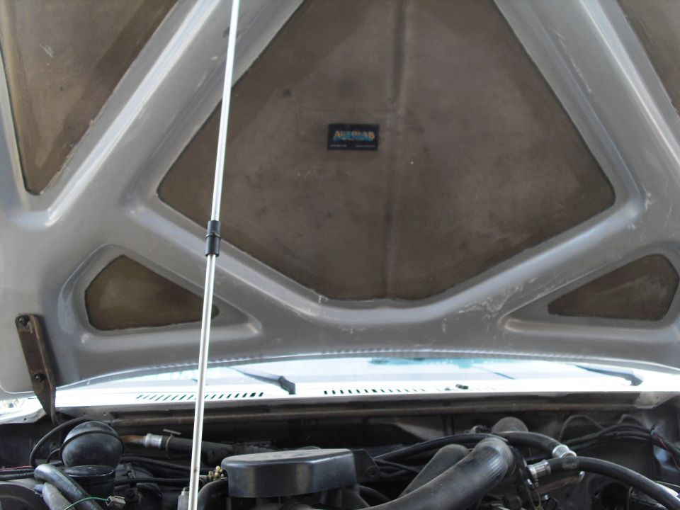 Under the hood of a 1986 Ford Bronco, showing the engine and hood insulation