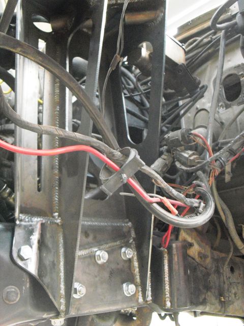 1986 Ford Bronco - Close-up view of custom fabricated suspension mounts and wiring harness in a vehicle's engine bay.