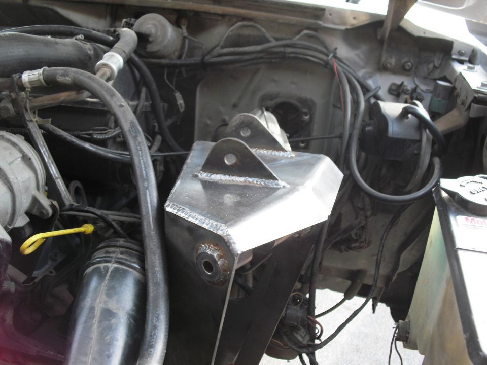 Custom metal shock tower mount in engine bay, looks like it's for a truck or SUV