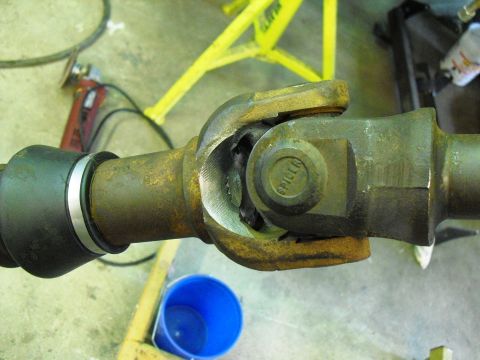 1986 Ford Bronco - A close-up view of a driveshaft U-joint, showing wear and the 'SPICER' brand on one of the bearing caps.