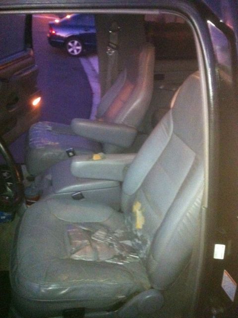 1996 Ford Bronco - Interior view of a vehicle with torn seats and a glimpse of another car outside.
