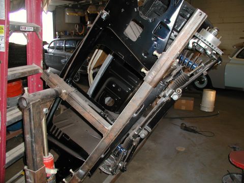 1960 Ford Ranchero - A vehicle's chassis is suspended by an engine hoist in a workshop setting.