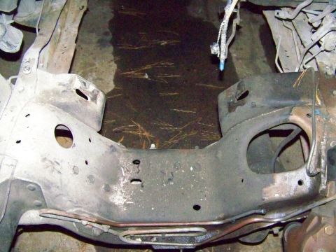 1985 Ford Bronco - The underside of a vehicle frame is shown, with evidence of rust and wear.