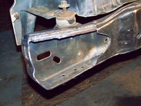1985 Ford Bronco - Close-up of a modified vehicle frame shows extensive welding and a suspension mounting point.