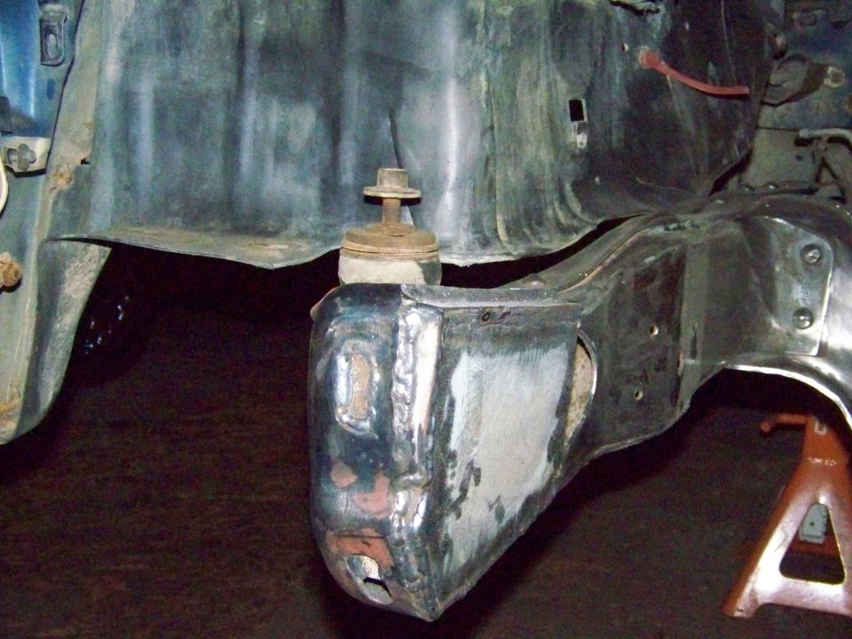 Close-up of a vehicle's frame with suspension parts, showing welding and modifications