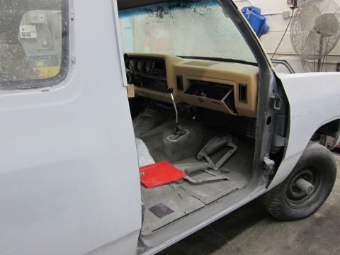 1987 Dodge 1500 - The interior of a Dodge Ram pickup truck is shown, with the driver's side door open and the dashboard visible.