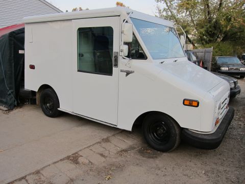 1991 Ford LTD Crown Victoria - A white Grumman LLV delivery truck is parked outdoors, showing its front and side profile.