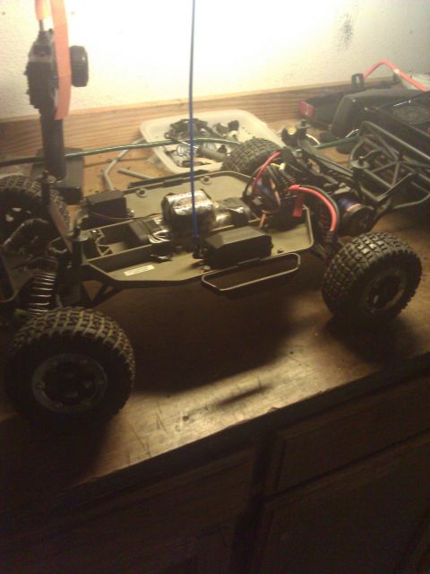 1994 Ford Bronco - The chassis of a remote control car is shown with its internal components and large off-road tires visible.
