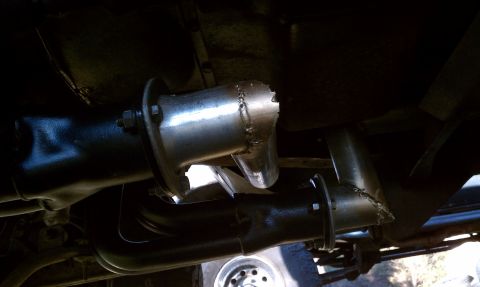 1979 Ford Bronco - Close-up view of a damaged exhaust system on a vehicle.