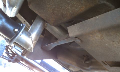 1979 Ford Bronco - Underside view of vehicle exhaust system components and mounting hardware.