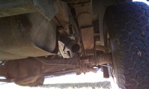 1979 Ford Bronco - A low-angle shot reveals the rear axle, fuel tank, and exhaust system of a vehicle.