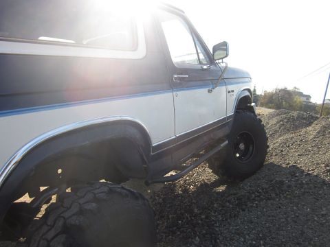 1985 Ford Bronco - This 1985 Ford Bronco features a two-tone paint scheme and is equipped with large off-road tires.