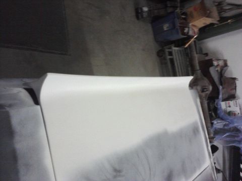 1966 Ford Mustang - A white 1966 Ford Mustang hood is shown in a workshop, likely being prepped for paint.
