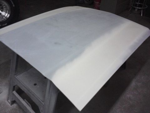 1966 Ford Mustang - Car hood undergoing bodywork, resting on a stand in a workshop.